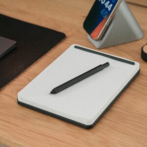 A pen, tablet, and phone on a desk.